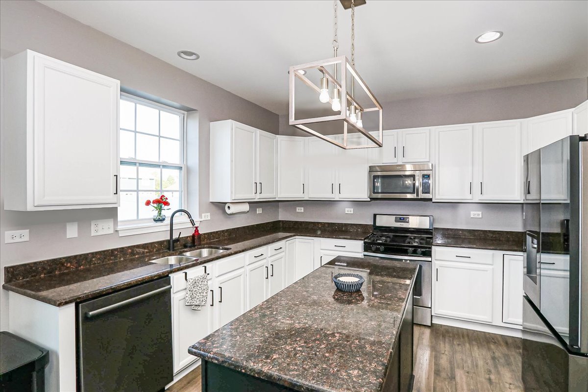 342 Snowdrop Lane Elgin, IL 60124 - Photo 8 of 28 a kitchen with stainless steel appliances granite countertop a sink a stove a refrigerator a center island and wooden floor