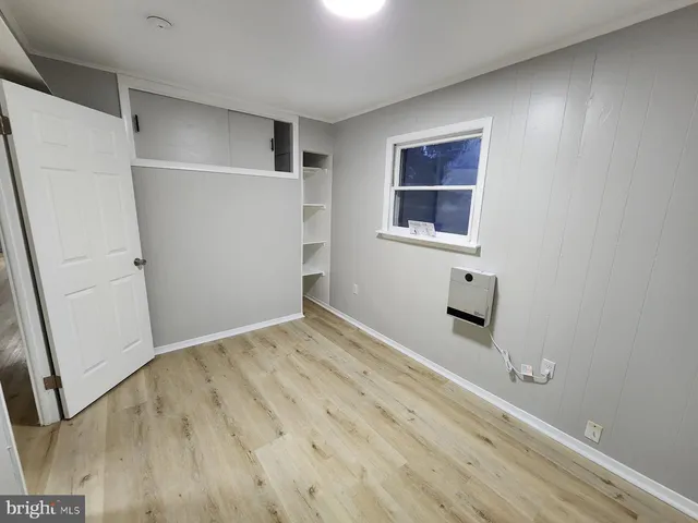 a view of empty room with wooden floor