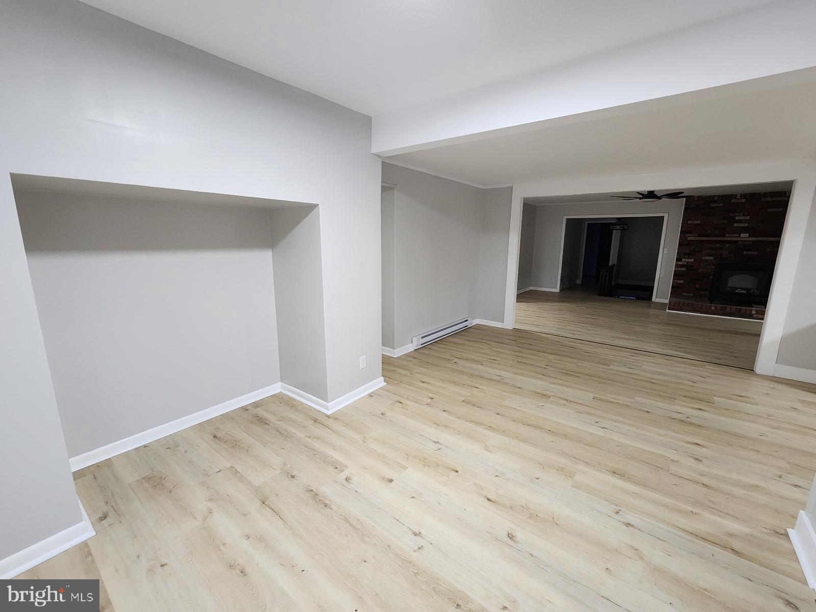 20307 Pond Circle Road Midlothian, MD 21543 - Photo 27 of 29 a view of an empty room with wooden floor and a kitchen