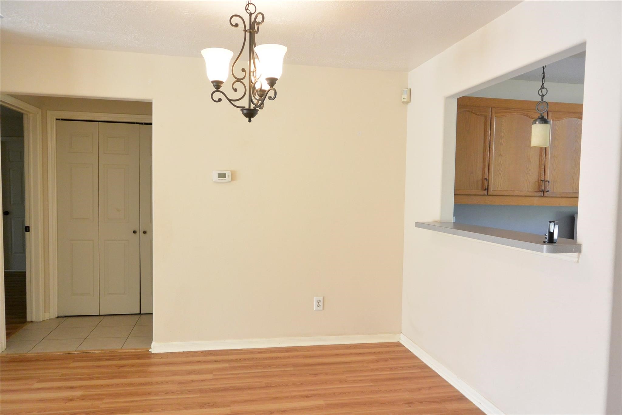 23615 Tree House Lane Spring, TX 77373 - Photo 9 of 12 a view of a hallway with wooden floor and chandelier