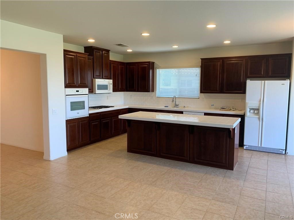 16965 Spring Canyon Place Riverside, CA 92503 - Photo 8 of 8 a kitchen with a sink a stove a refrigerator and a oven