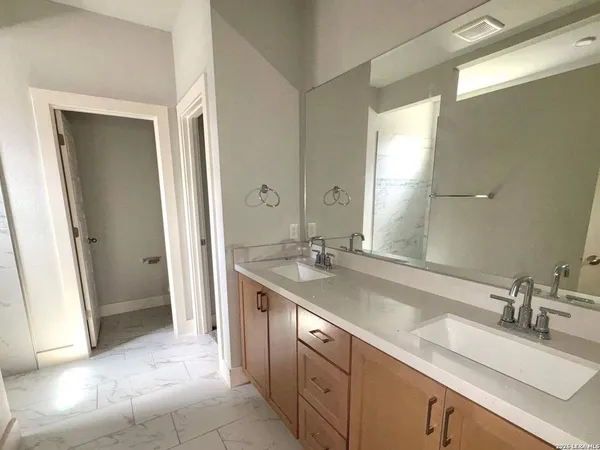 a spacious bathroom with a double vanity sink a and mirror