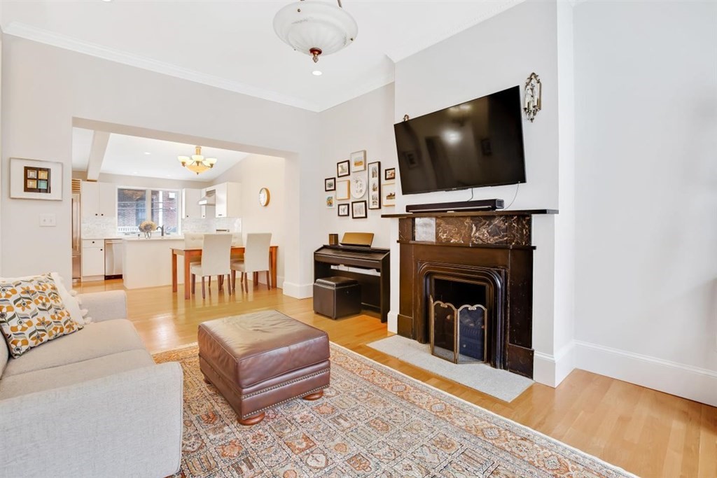a living room with furniture a flat screen tv and a fireplace