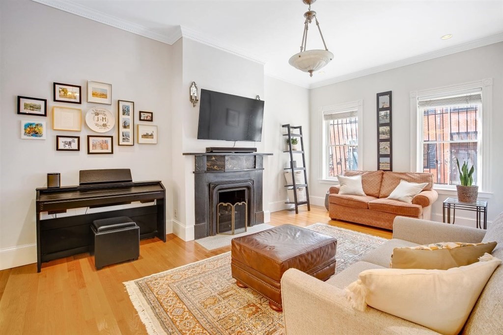 5 Bond Street, Unit 1 Boston, MA 02118 - Photo 2 of 18 a living room with furniture a flat screen tv and a fireplace