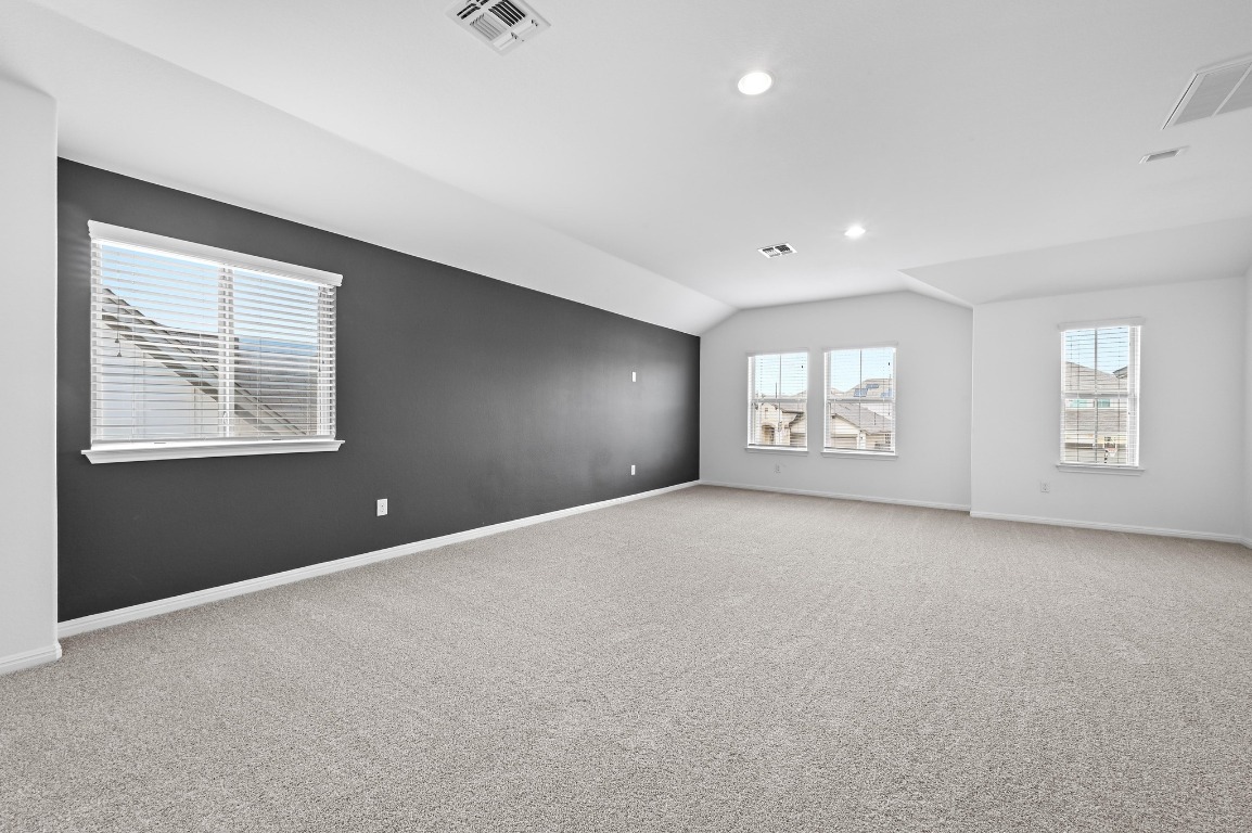 13221 Mariscan Street Manchaca, TX 78652 - Photo 22 of 36 Empty room featuring vaulted ceiling, carpet flooring, and recessed lighting