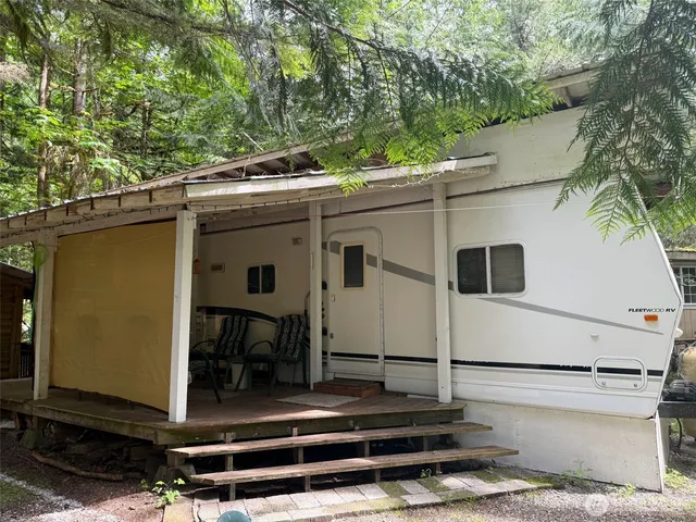 a view of a patio with table and chairs with wooden fence and plants