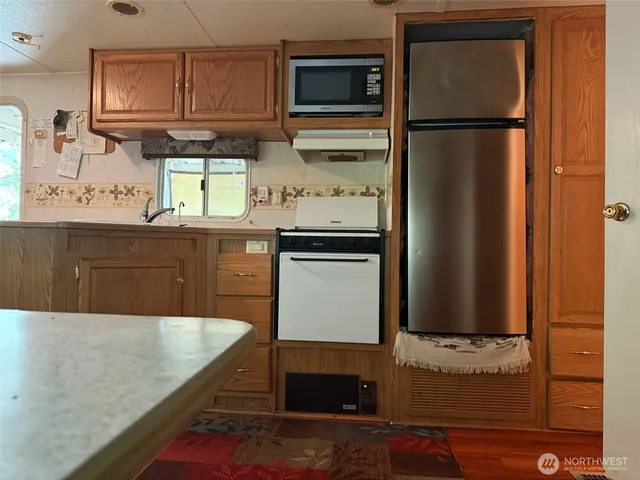 a kitchen with stainless steel appliances granite countertop a refrigerator and a stove top oven