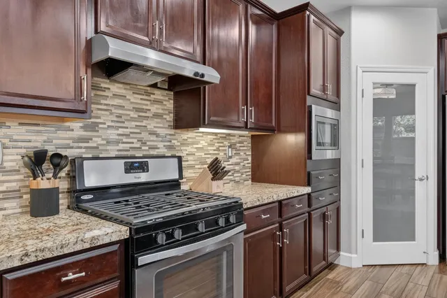 a view of a dining room and livingroom with furniture wooden floor and a rug