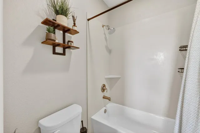 a view of a patio with a table and chairs and a barbeque