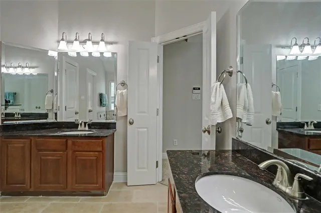 a bathroom with a granite countertop sink mirror and a bathtub