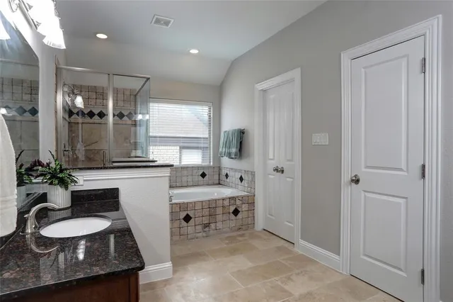 a bathroom with a granite countertop sink double vanity and mirror