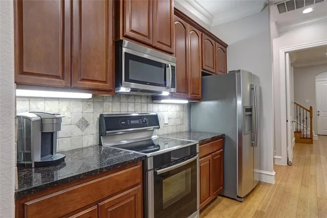 a kitchen with stainless steel appliances granite countertop a refrigerator stove and microwave