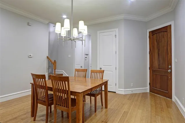 a kitchen with stainless steel appliances kitchen island granite countertop a table chairs in it and a wooden floors