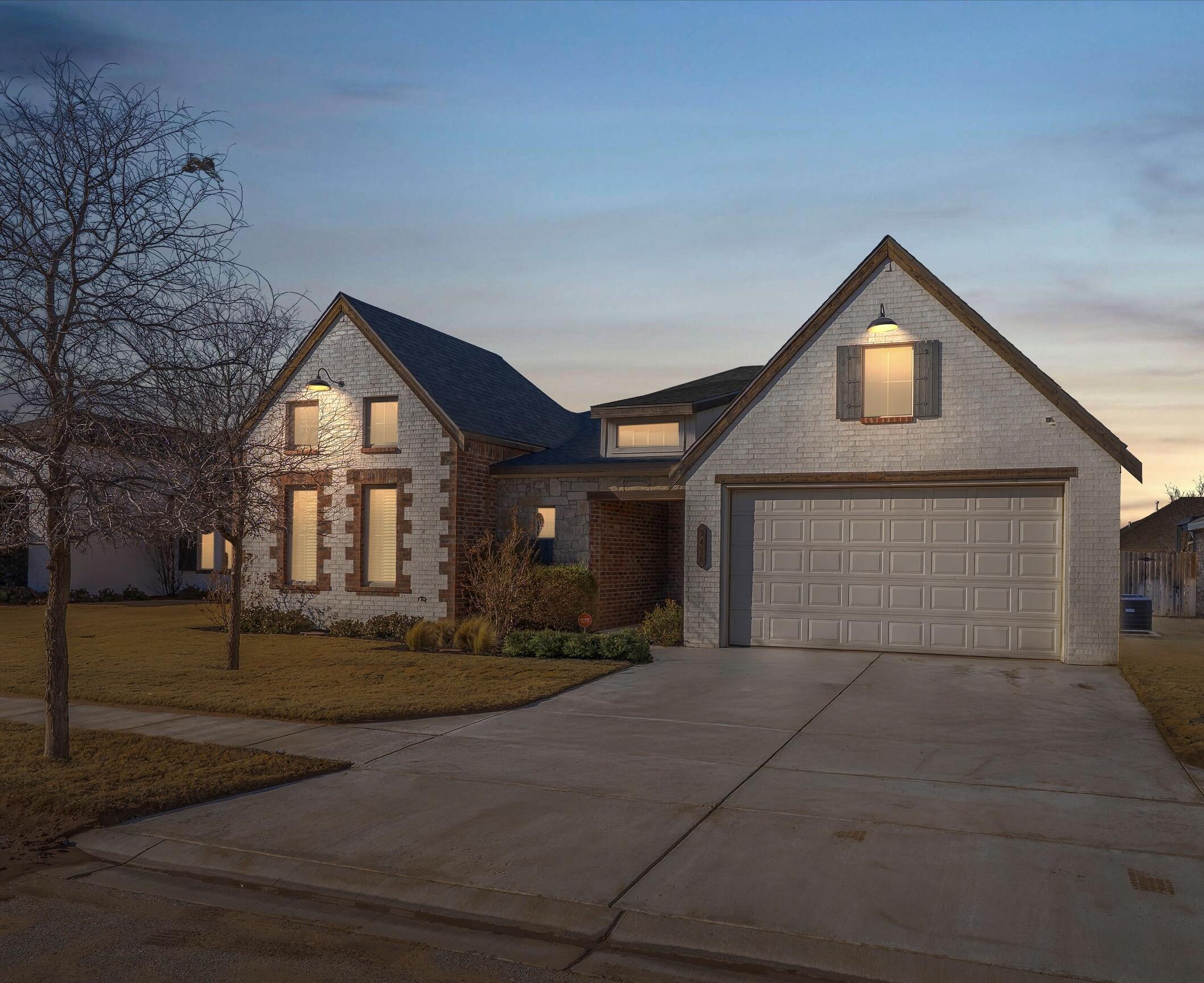 a front view of a house with yard and garage