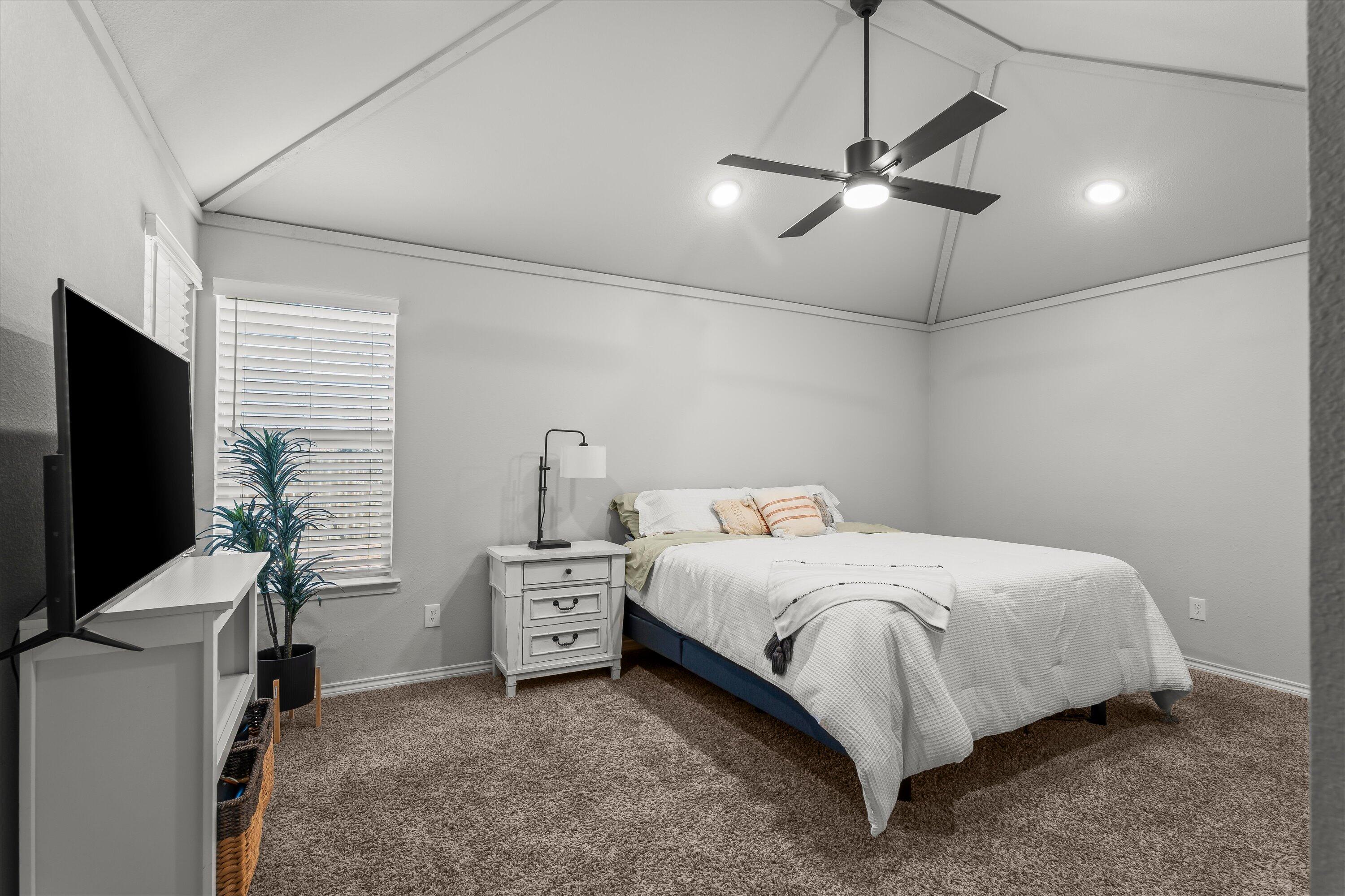 3438 125th Street Lubbock, TX 79423 - Photo 15 of 34 a bedroom with a bed and a flat screen tv