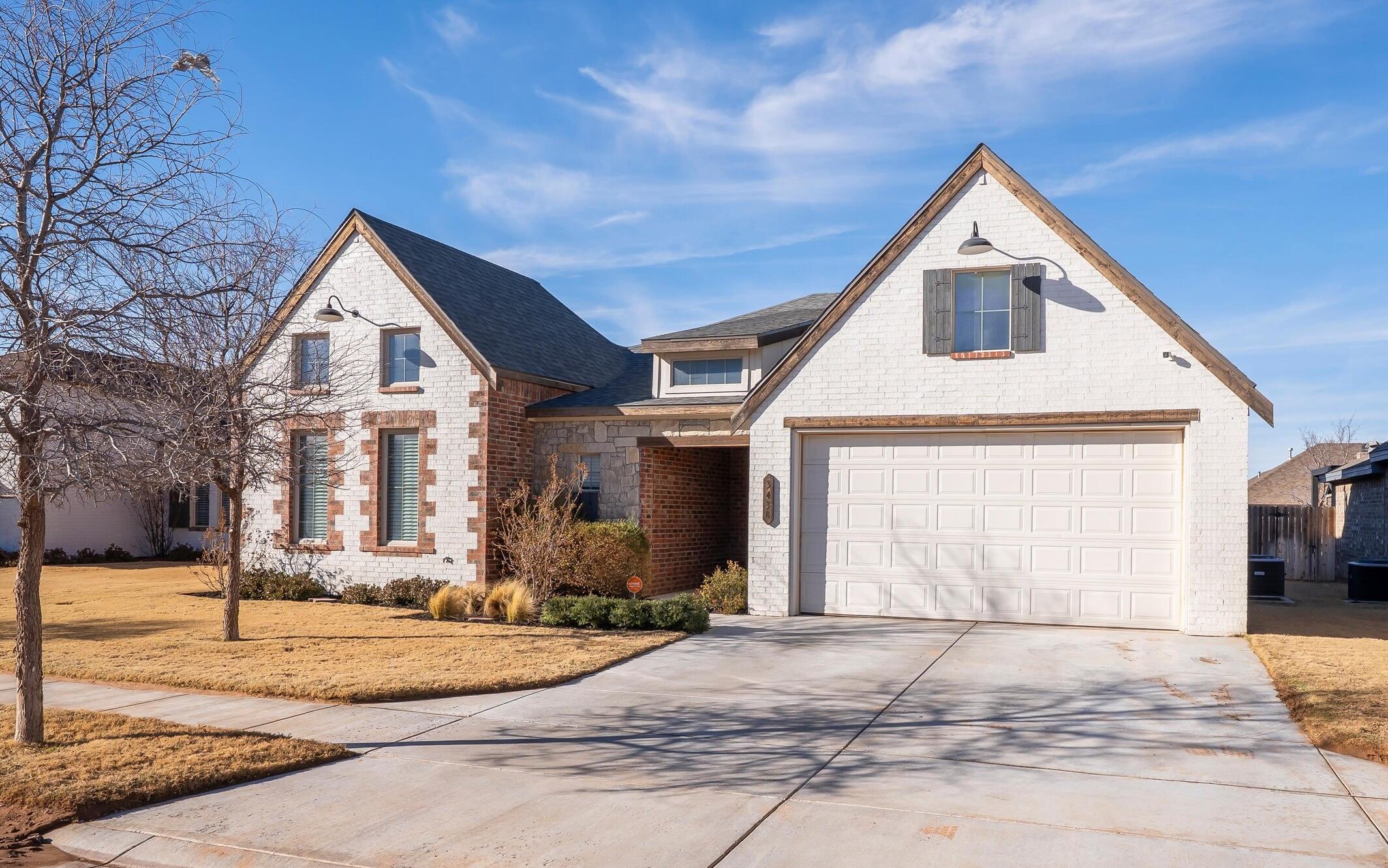 3438 125th Street Lubbock, TX 79423 - Photo 2 of 34 a front view of a house with a yard and garage