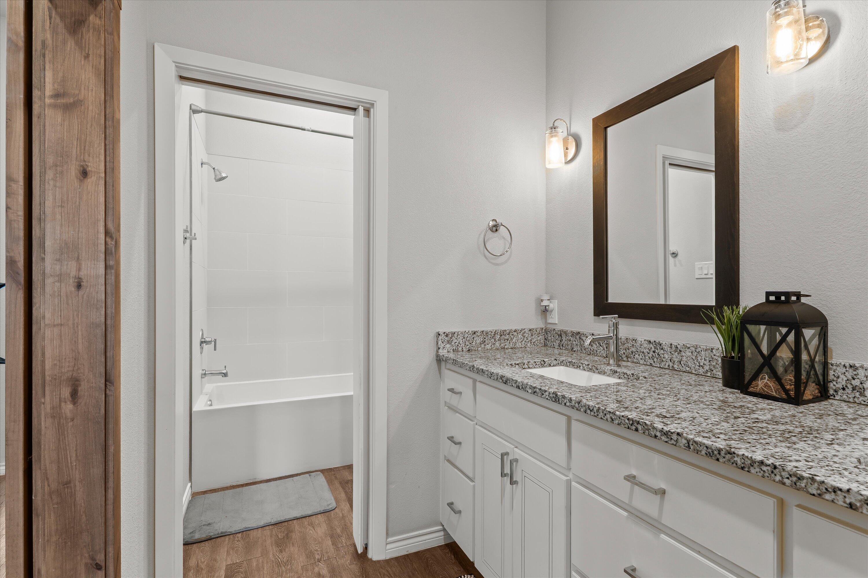 3438 125th Street Lubbock, TX 79423 - Photo 23 of 34 a bathroom with a granite countertop sink and a mirror
