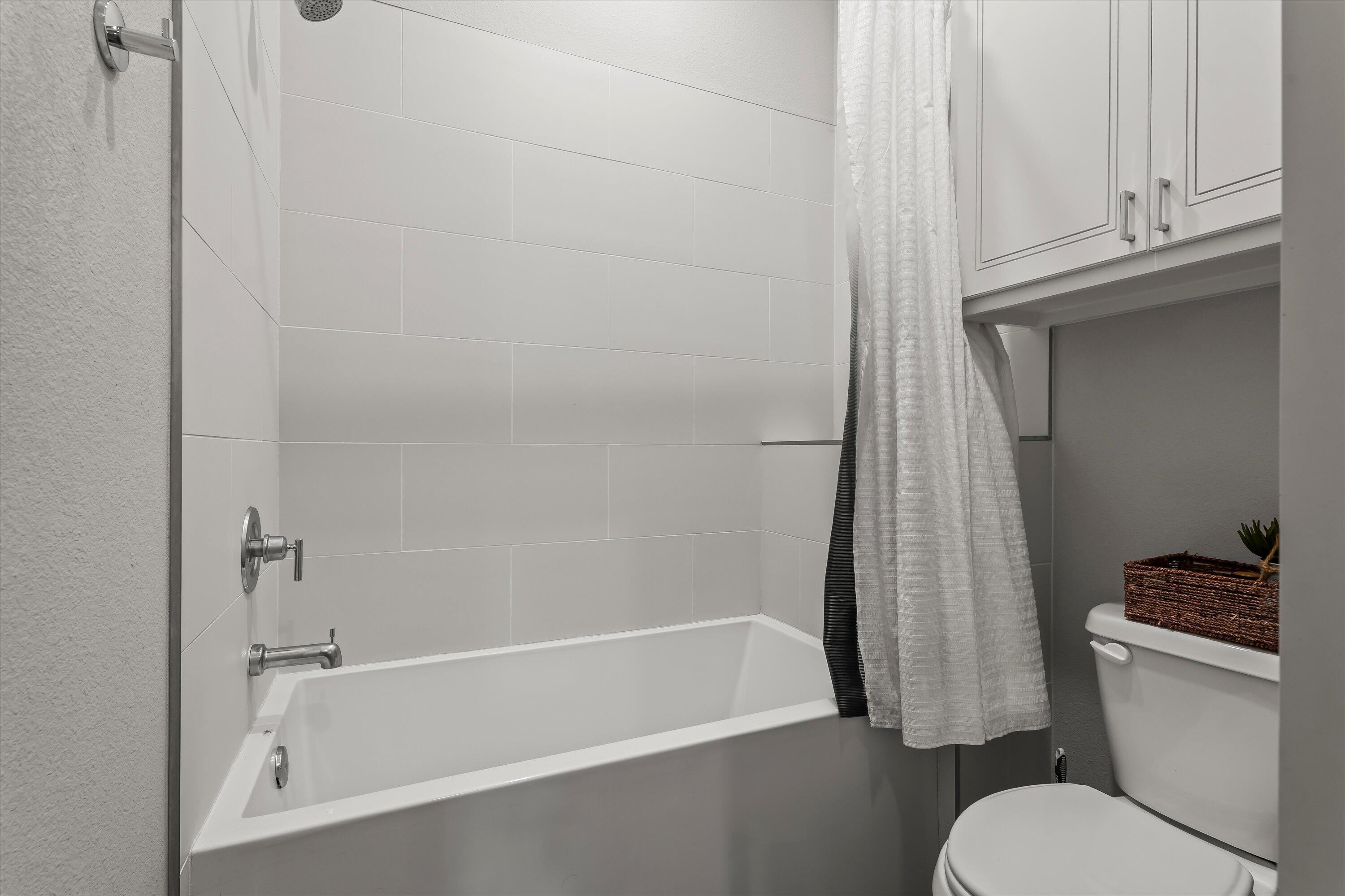 3438 125th Street Lubbock, TX 79423 - Photo 24 of 34 a bathroom with a toilet and a shower curtain
