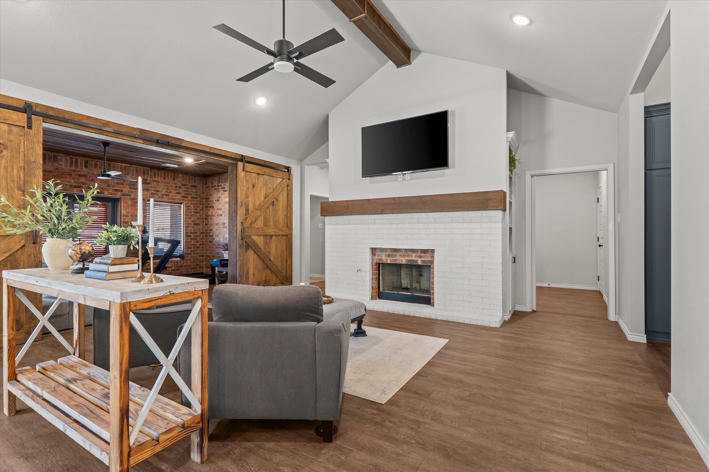 3438 125th Street Lubbock, TX 79423 - Photo 6 of 34 a living room with furniture a fireplace and a flat screen tv