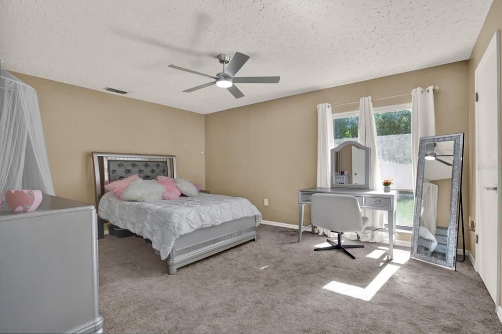 7487 River Country Drive Weeki Wachee, FL 34607 - Photo 32 of 53 a bedroom with a bed a table and large mirror with window