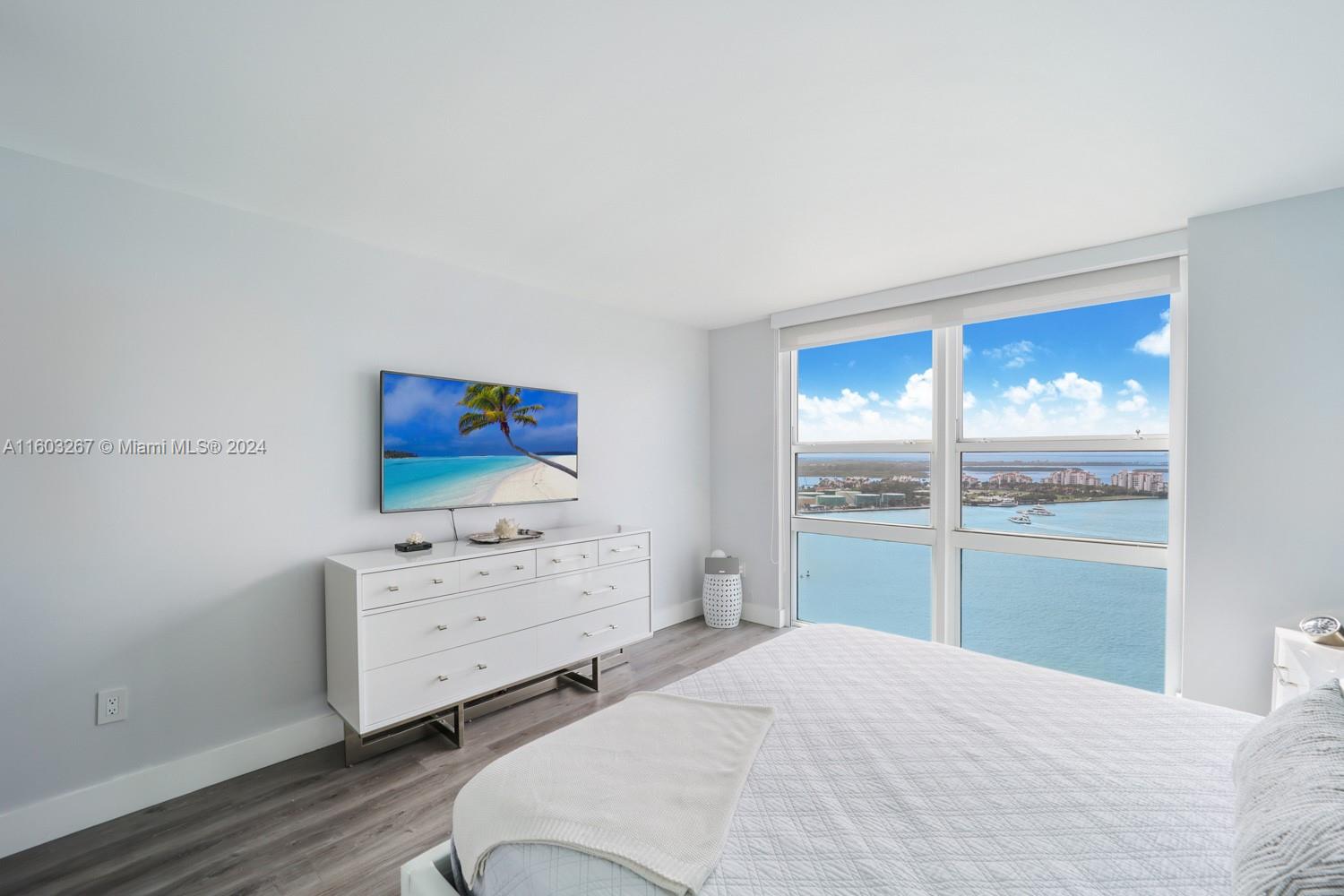 90 Alton Road, Unit 2806 Miami Beach, FL 33139 - Photo 12 of 36 a bedroom with a bed and a cabinets