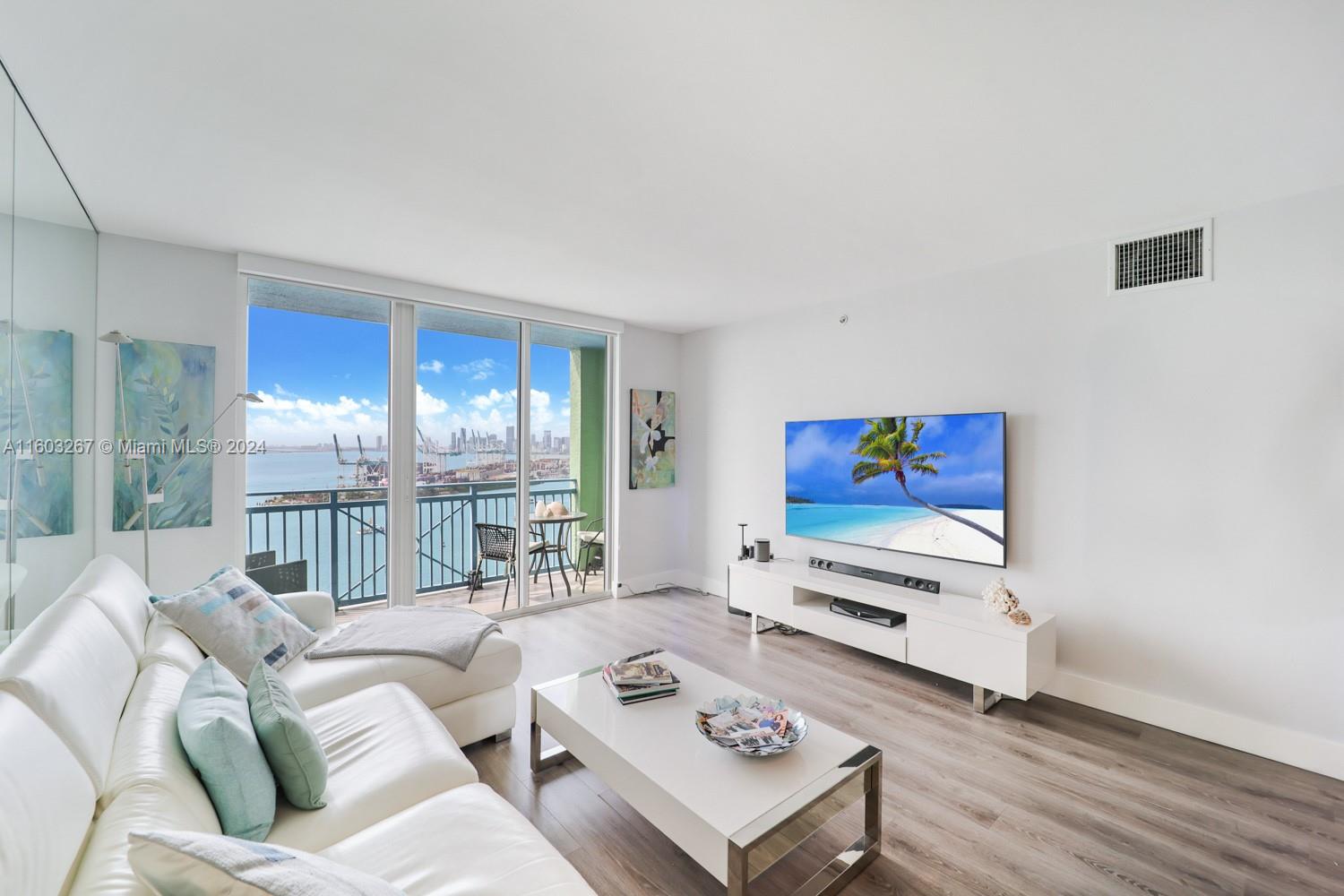 90 Alton Road, Unit 2806 Miami Beach, FL 33139 - Photo 8 of 36 a living room with furniture and a flat screen tv