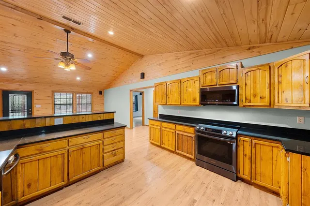 a kitchen with stainless steel appliances granite countertop wooden cabinets and a refrigerator