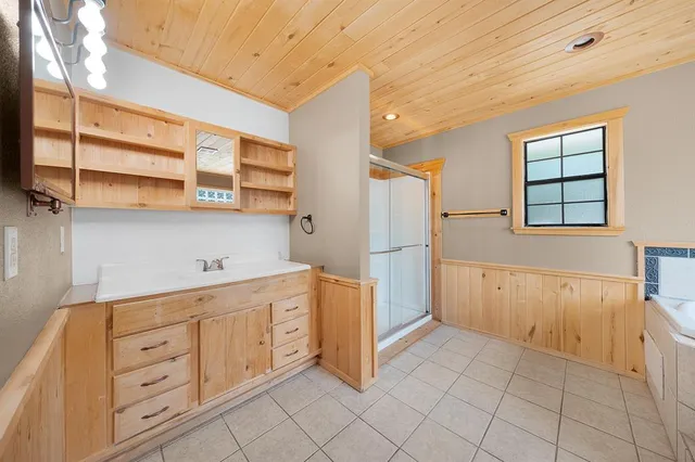 a kitchen with white cabinets and window