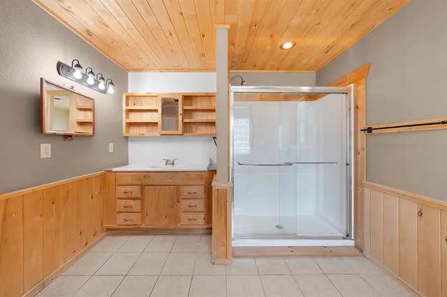 a bathroom with a granite countertop sink a mirror and a shower