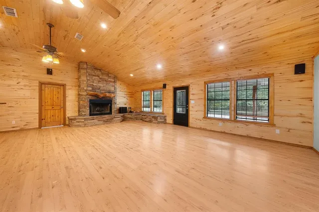 a view of an empty room with a fireplace and a window