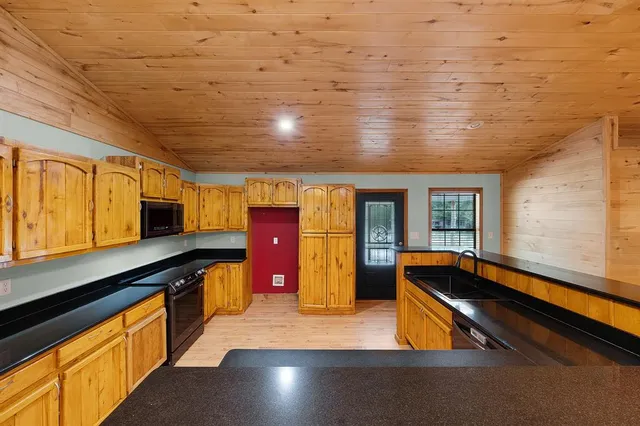 a kitchen with stainless steel appliances wooden cabinets a sink and a stove