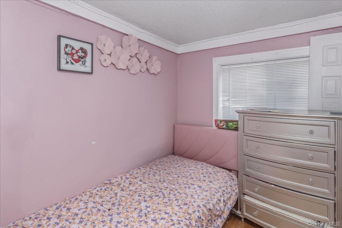237 Rhodes Avenue Hempstead, NY 11550 - Photo 13 of 24 a bedroom with a bed and a window