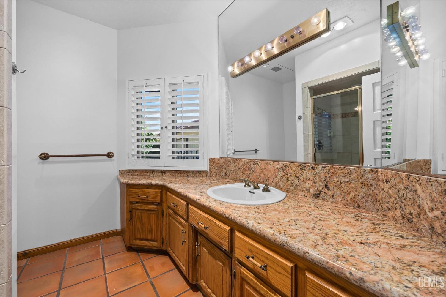 Undisclosed Address Bakersfield, CA 93306 - Photo 36 of 75 a bathroom with a granite countertop sink and a window