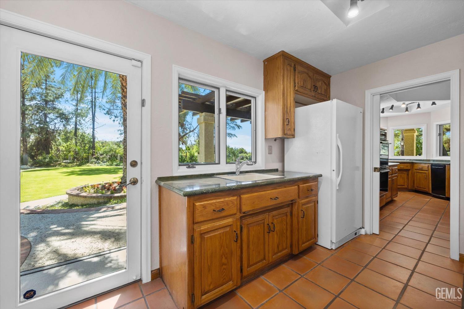 Undisclosed Address Bakersfield, CA 93306 - Photo 37 of 75 a kitchen with a refrigerator a stove top oven and a large window