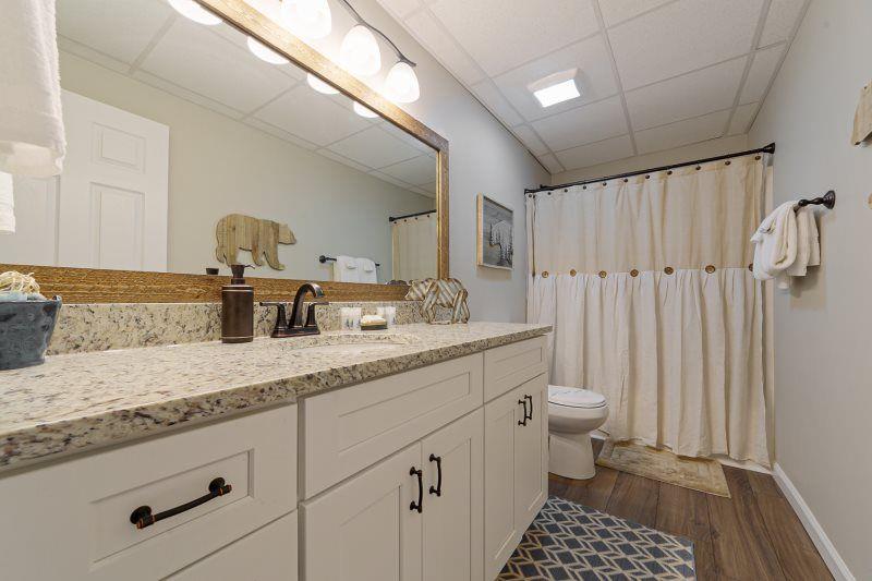 39 Schwarzwald Strasse Helen, GA 30545 - Photo 21 of 25 a bathroom with a granite countertop sink a toilet and a shower