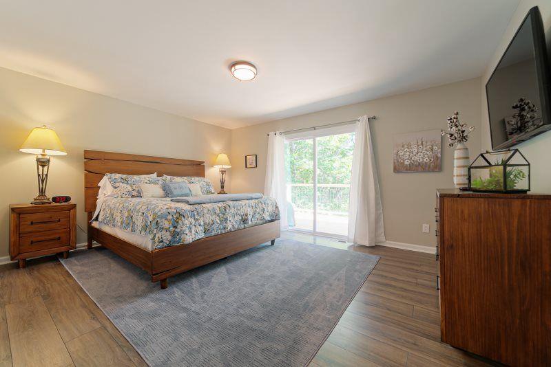 39 Schwarzwald Strasse Helen, GA 30545 - Photo 7 of 25 a bedroom with a bed a flat screen tv and dresser next to a window