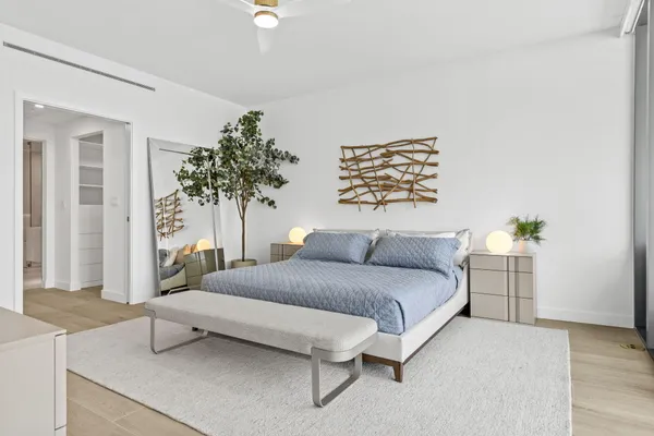 a bedroom with a bed and a potted plant