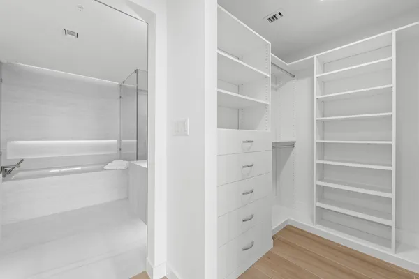 a view of walk in closet with empty racks