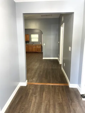 an empty room with wooden floor and a bathroom