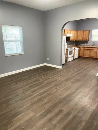 a view of a kitchen with a sink wooden cabinets and a window