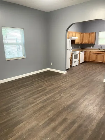 a view of a kitchen with a sink wooden cabinets and a window