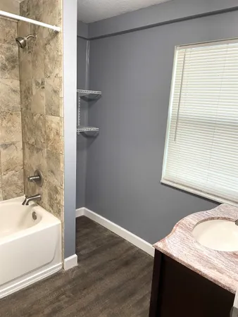 a bathroom with a granite countertop sink and a bathtub