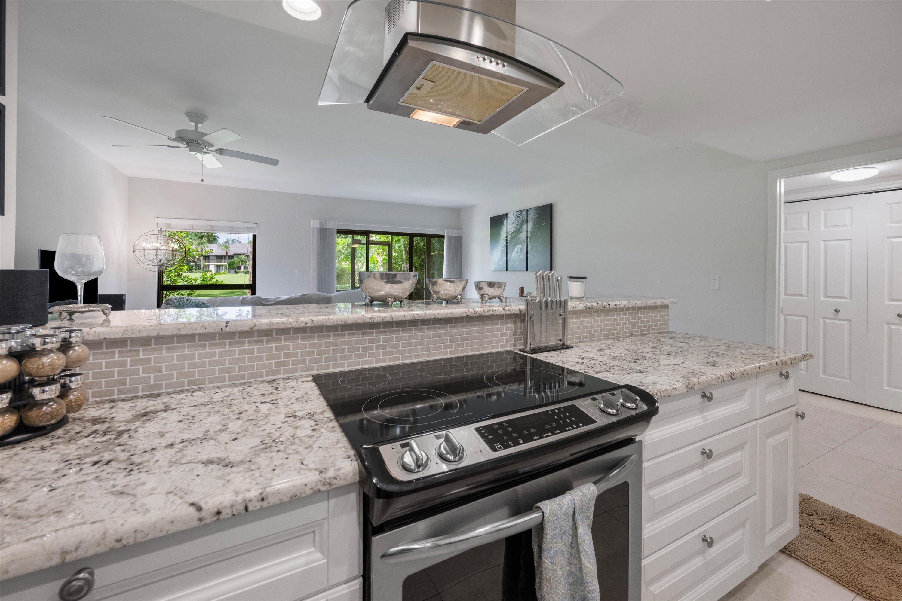 13334 Polo Club Road, Unit 228 Wellington, FL 33414 - Photo 12 of 26 a kitchen with granite countertop a stove and a sink