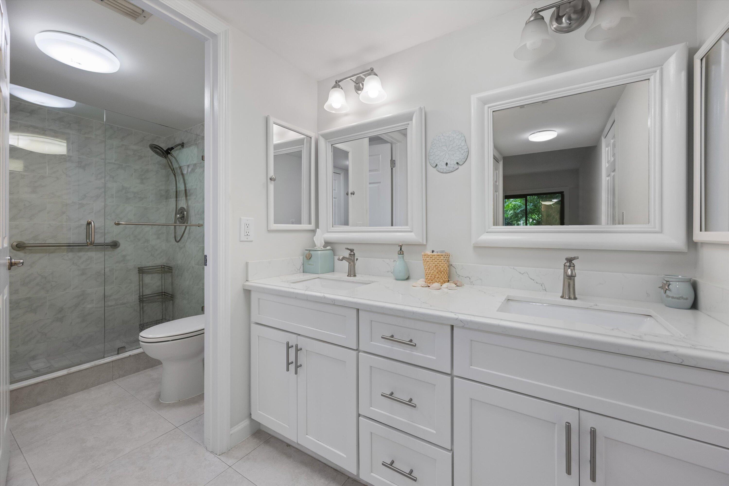 13334 Polo Club Road, Unit 228 Wellington, FL 33414 - Photo 14 of 26 a bathroom with a double vanity sink toilet and a mirror