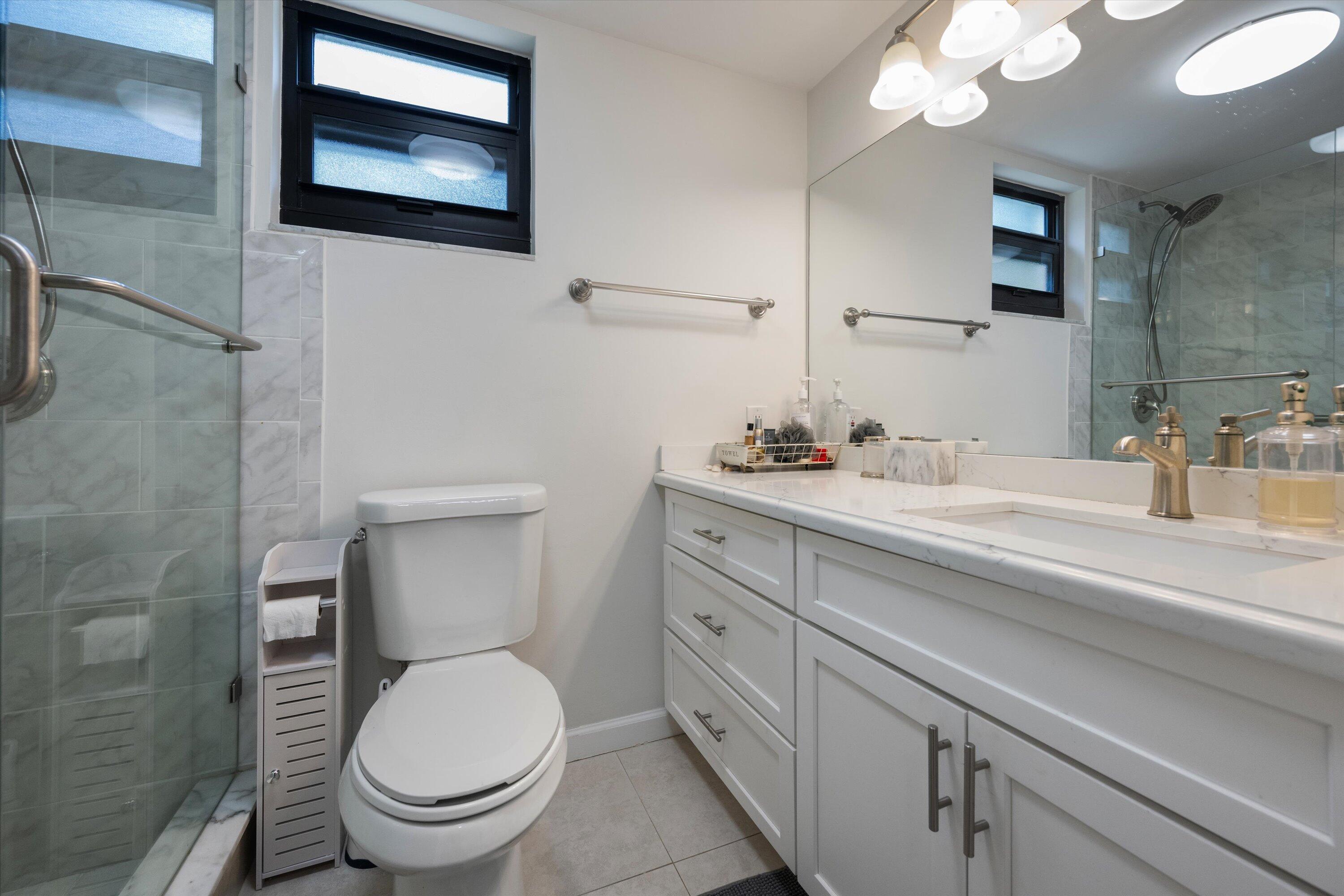 13334 Polo Club Road, Unit 228 Wellington, FL 33414 - Photo 19 of 26 a bathroom with a toilet sink and mirror