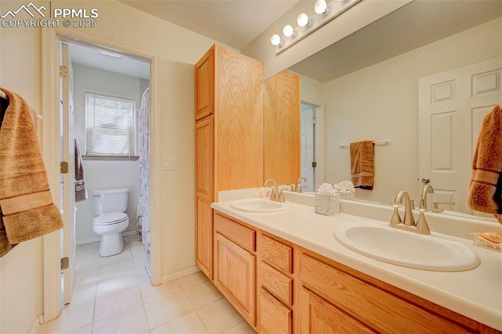 840 West Kelly Road Woodland Park, CO 80863 - Photo 20 of 47 Full bath featuring toilet, tile patterned flooring, a sink, and double vanity