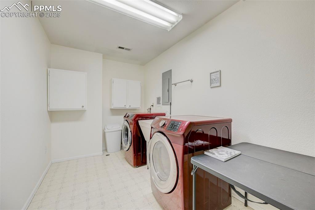 840 West Kelly Road Woodland Park, CO 80863 - Photo 35 of 47 Washroom featuring light floors, visible vents, electric panel, washing machine and clothes dryer, and cabinet space