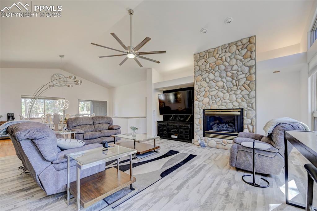 840 West Kelly Road Woodland Park, CO 80863 - Photo 4 of 47 Living area with high vaulted ceiling, a ceiling fan, wood finished floors, and a fireplace