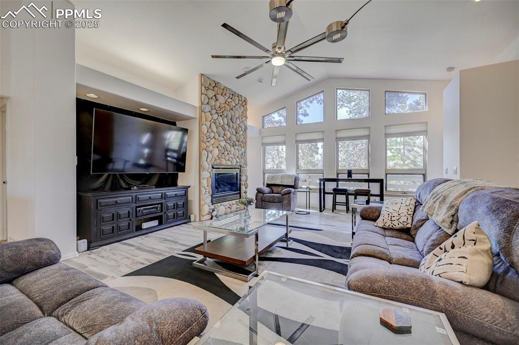 840 West Kelly Road Woodland Park, CO 80863 - Photo 5 of 47 Living room featuring a fireplace, vaulted ceiling, and wood finished floors