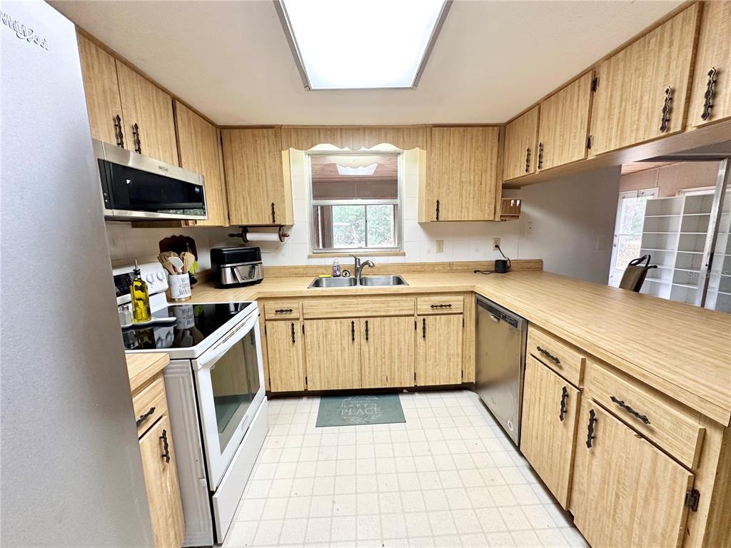 7414 Acorn Circle Spring Hill, FL 34606 - Photo 19 of 50 a kitchen with a sink a stove top oven a refrigerator and cabinets